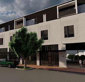 A modern building with a green truck parked in front.