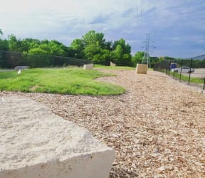 a small patch of grass in the middle of a gravel area