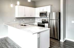 a kitchen with white cabinets and a stainless steel refrigerator