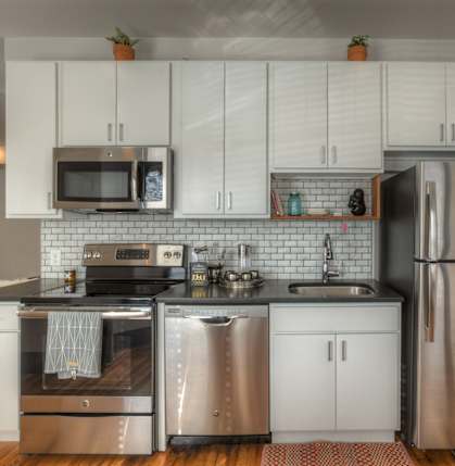 A kitchen with white cabinets and stainless steel appliances.