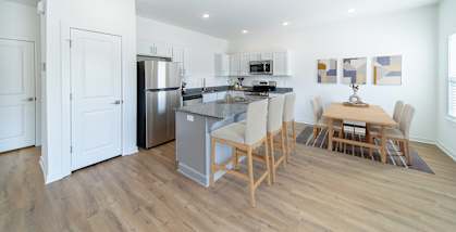 a living room with a kitchen and a dining table