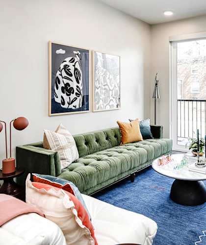 A living room with a green couch and a white coffee table.
