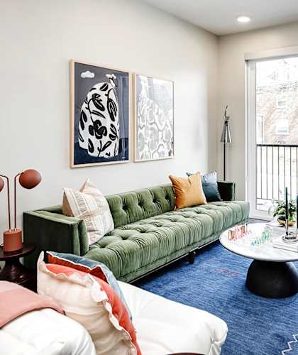 A living room with a green couch and a blue rug.