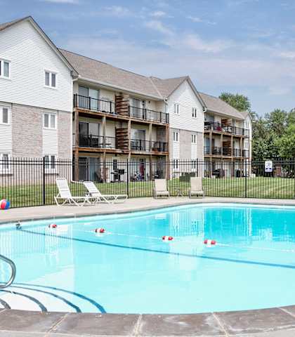 A swimming pool in front of apartment buildings.