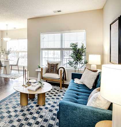 A living room with a blue couch and a coffee table at Autumn Grove Apartments, Nebraska