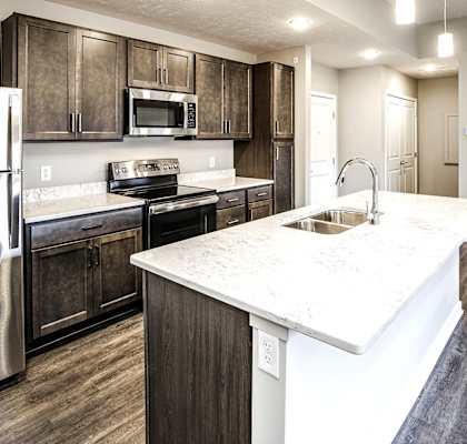 a kitchen with stainless steel appliances and a marble counter top