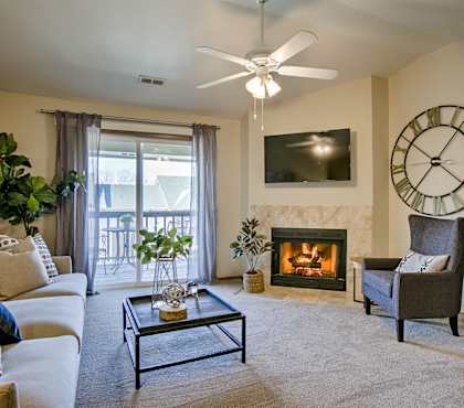 A living room with a fireplace, a couch, a chair, and a television.