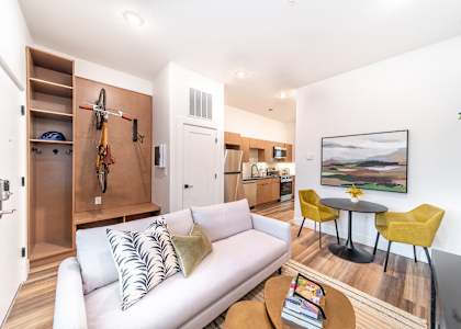 A living room with a white couch, a coffee table, and a painting on the wall.