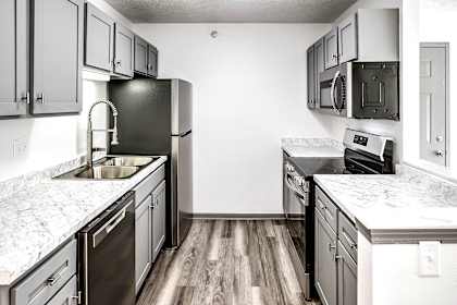 an empty kitchen with marble counter tops and stainless steel appliances