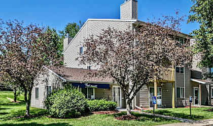 an apartment building with a tree in front of it
