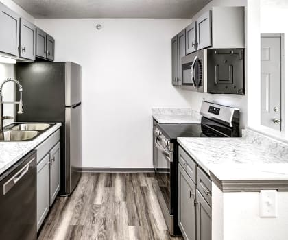 an empty kitchen with marble counter tops and stainless steel appliances