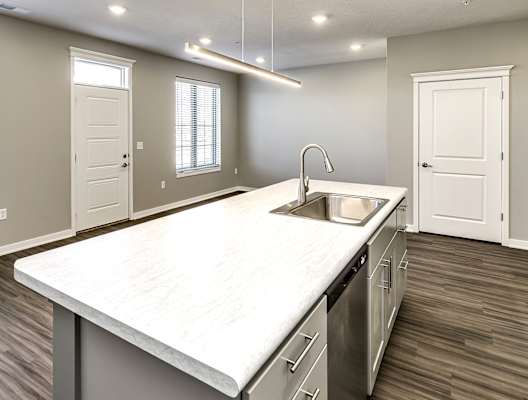 an empty kitchen with a large counter top and a sink