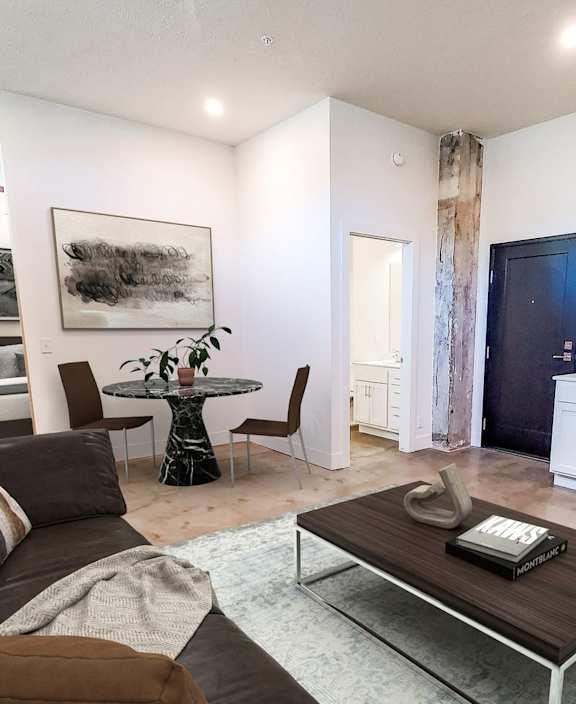 A living room with a brown couch and a coffee table.