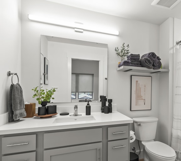 a bathroom with a white countertop and a white shower curtain