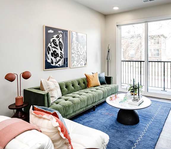 A living room with a green couch and a white coffee table.