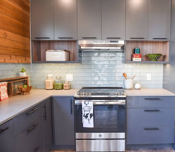 a kitchen with blue cabinets and a stainless steel stove and refrigerator