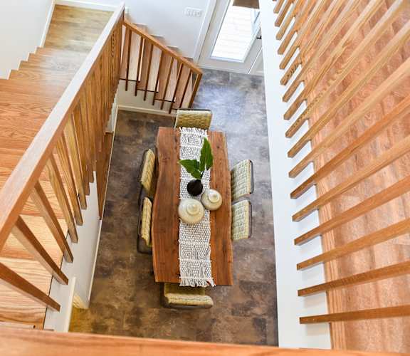 a view of a dining room table from the top of the stairs