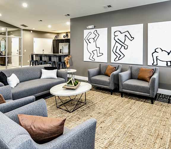 a lobby with couches and chairs and a coffee table in front of a wall with three