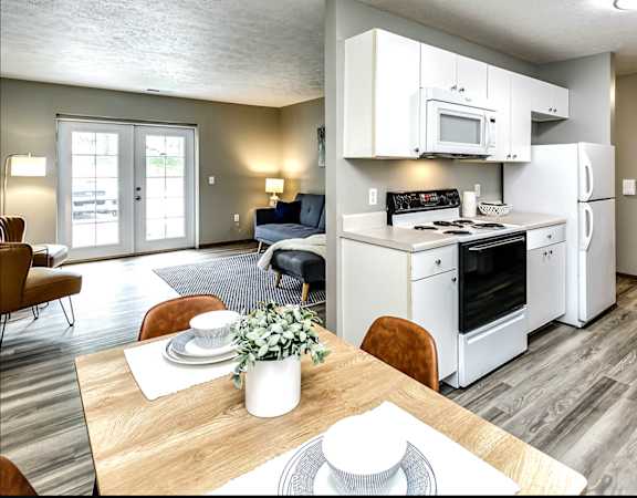 a kitchen and living room with a dining table and chairs