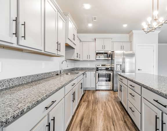 a white kitchen with marble counter tops and white cabinets