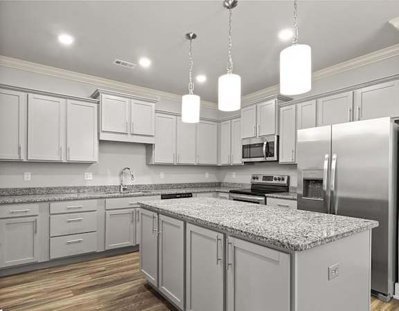 A kitchen with a granite countertop and stainless steel appliances.