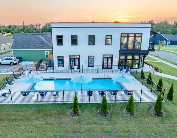 A white house with a pool in the backyard.