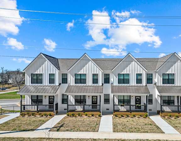 A row of identical houses with a clear blue sky above them.