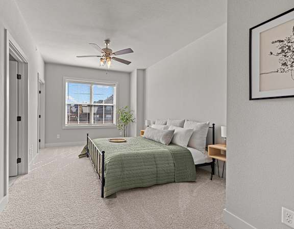 a bedroom with a bed and a ceiling fan