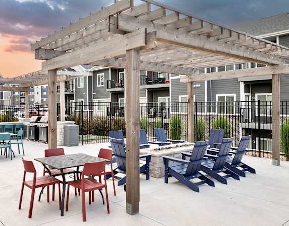 an outdoor patio with tables and chairs and a pergola