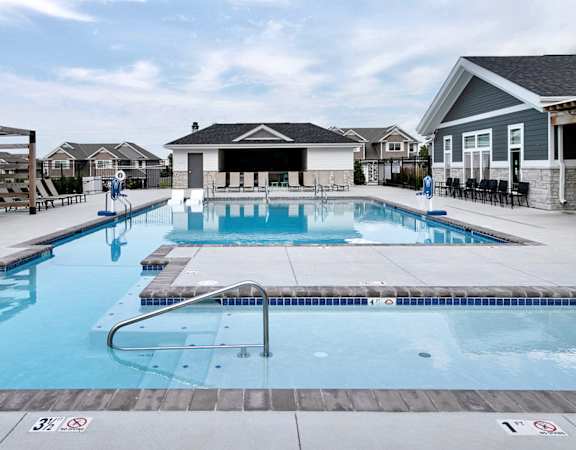 the resort style pool is next to a row of houses