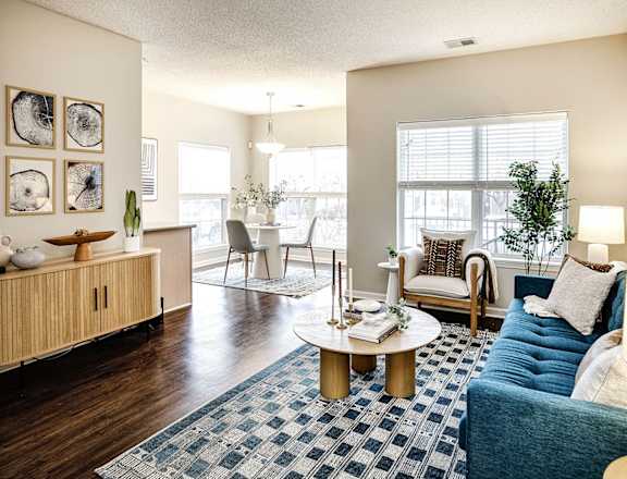A living room with a blue couch and a coffee table at Autumn Grove Apartments, Nebraska