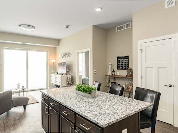 a kitchen and living room with a granite counter top