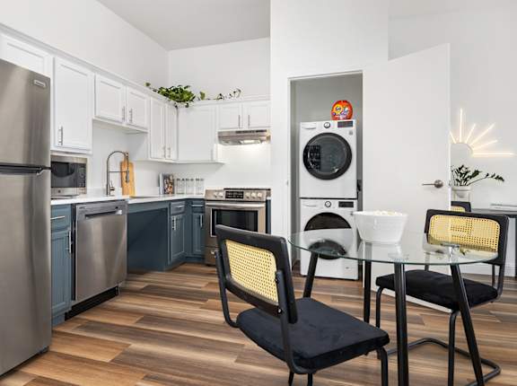 a kitchen with stainless steel appliances and a table with chairs