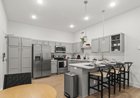 a kitchen with a large center island with a breakfast bar and stainless steel appliances