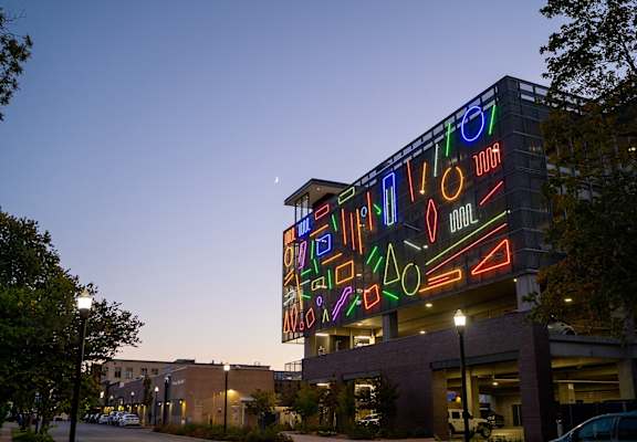 a large neon sign on the side of a building at night
