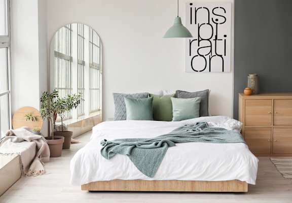 A bedroom with a large bed and a green blanket.