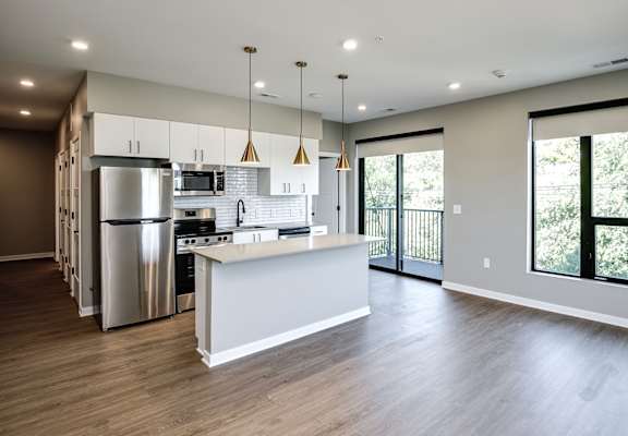 A modern kitchen with a white island and stainless steel appliances.