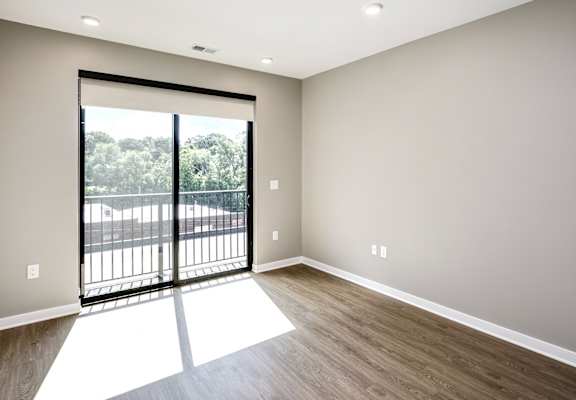A room with a sliding door leading to a balcony.