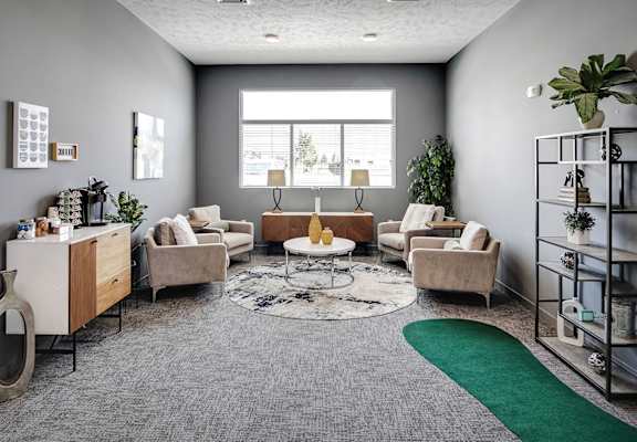 a living room with couches and chairs and a rug