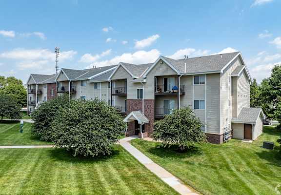 an apartment building with lawns and trees