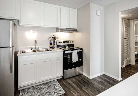 A modern kitchen with white cabinets and stainless steel appliances.