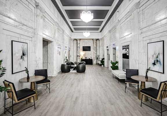 the lobby of a building with white marble walls and wood floors