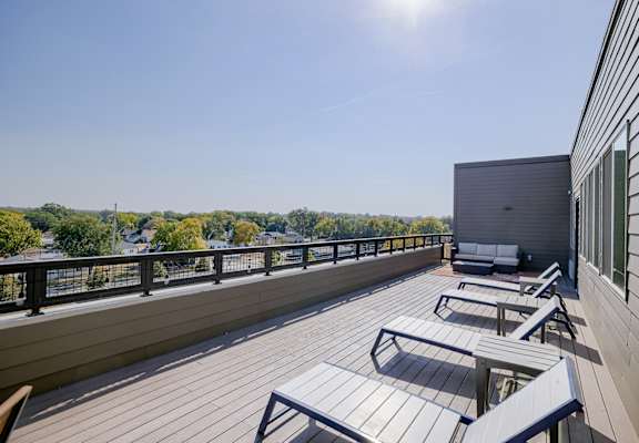 A sunny day on a wooden deck with a view of the trees.