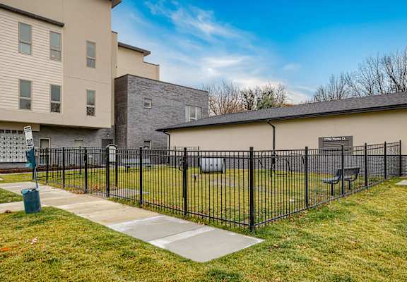 A black fence surrounds a small park area.