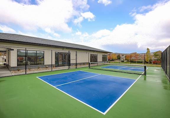A tennis court with a blue surface and white lines.