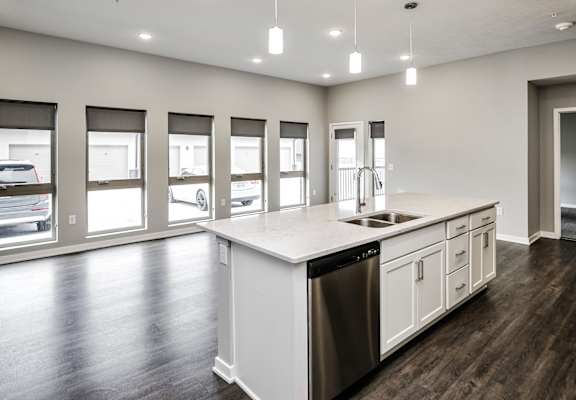 A modern kitchen with a large island and stainless steel appliances.