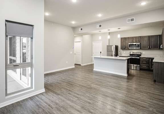 A kitchen with a white counter and wooden floors.