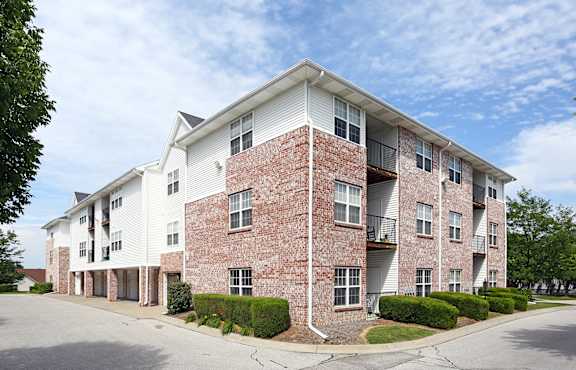 A large brick building with a white trim and balconies.