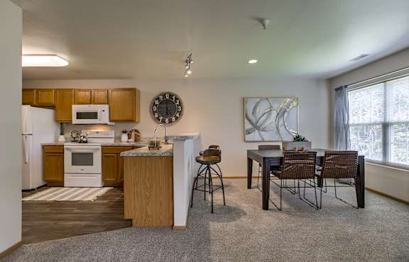 A kitchen with a dining table and chairs.