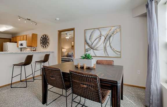A dining room with a table and chairs.